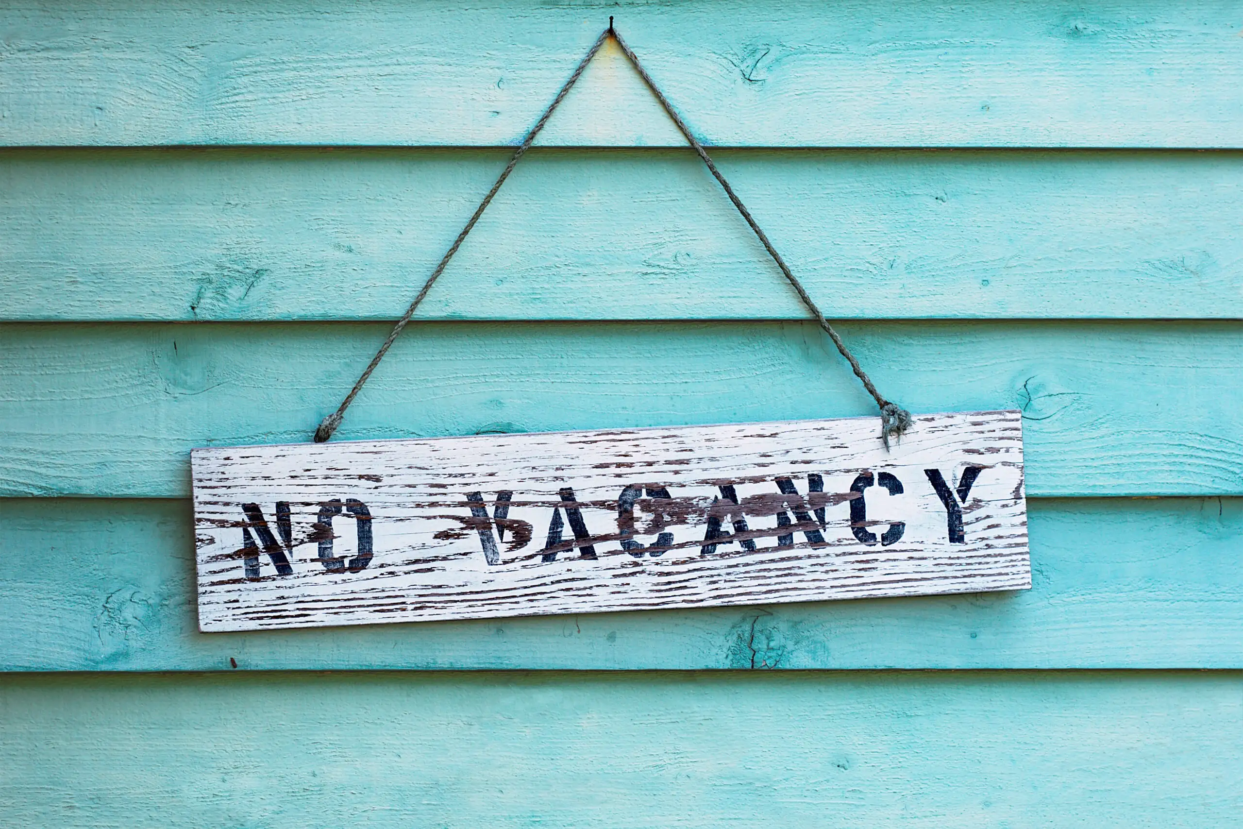 No Vacancy sign on a teal wall