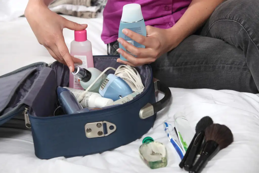 Close up of woman packing toiletry in a small bag for a week long trip