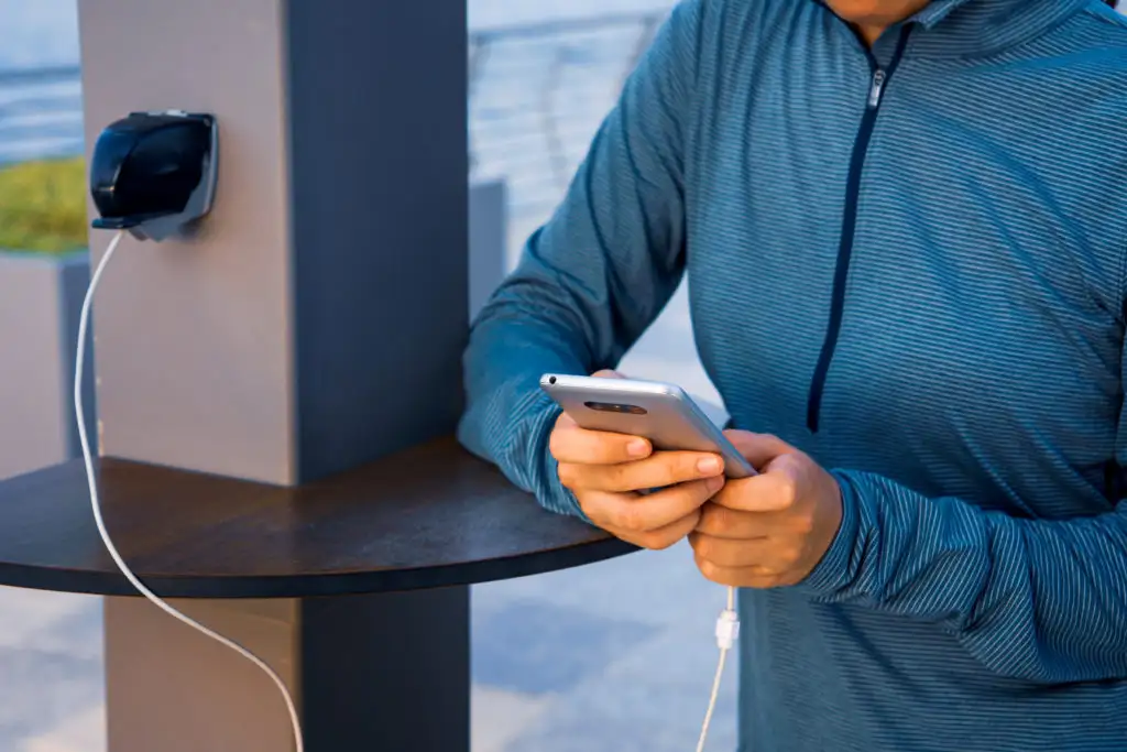 Person charging their cellphone at an airport charging station