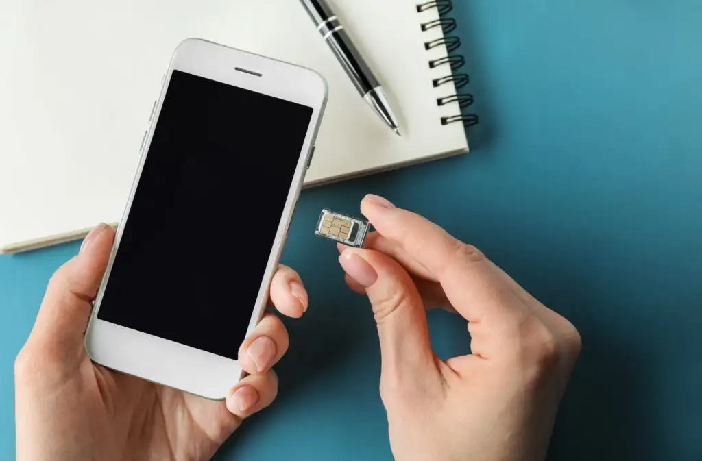 Person inserting a SIM card into a cellphone