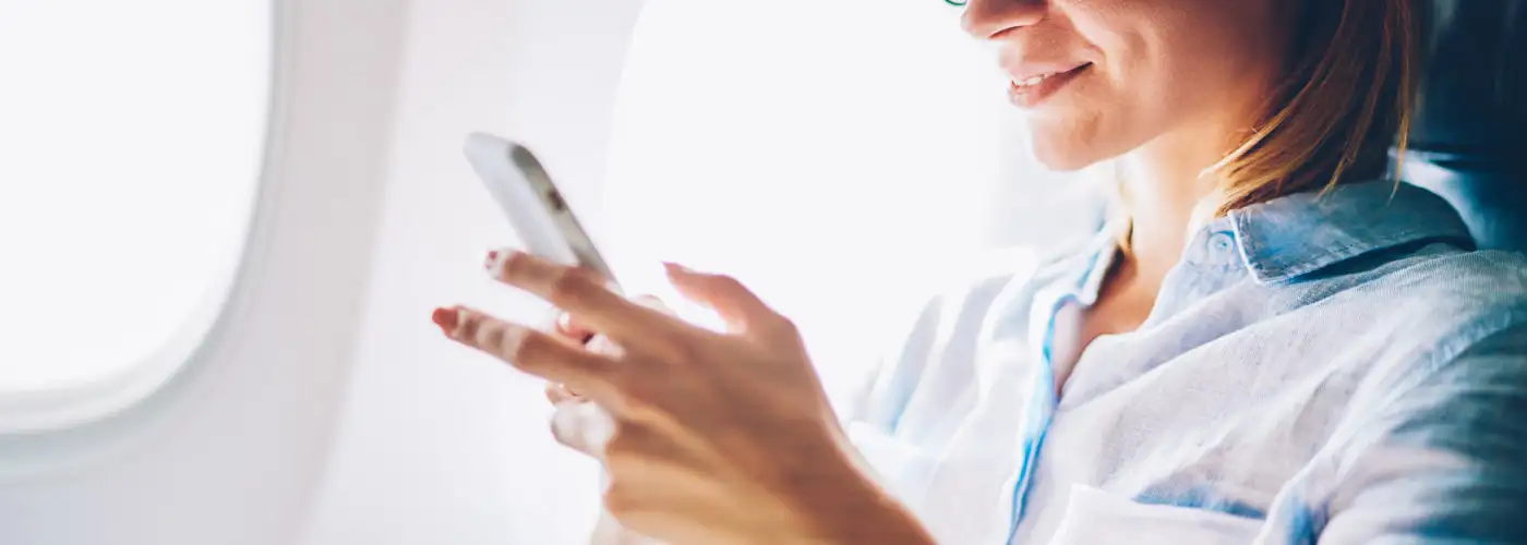 Woman using cellphone on plane