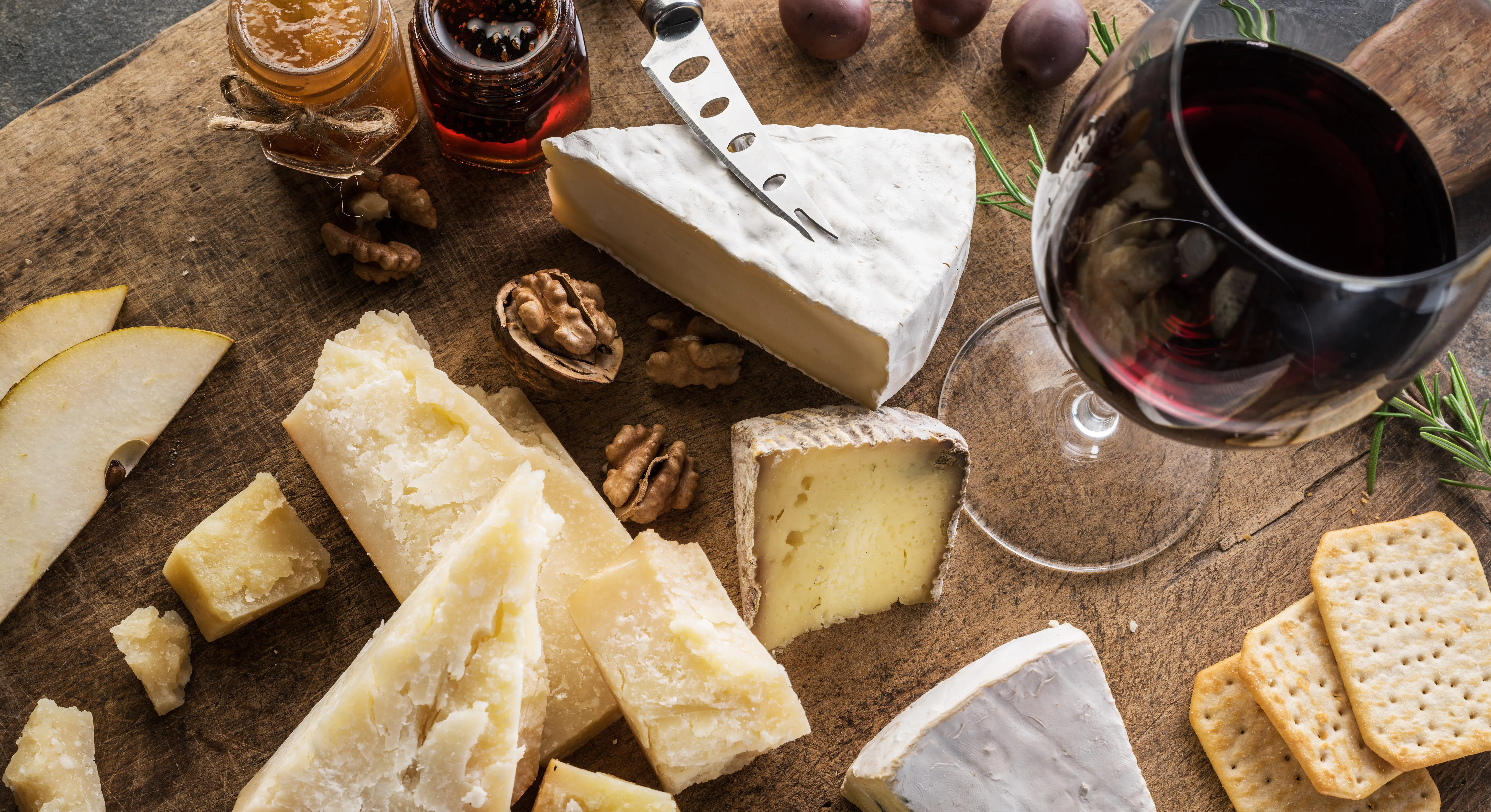 Cheese plate next to glass of red wine, as seen from above