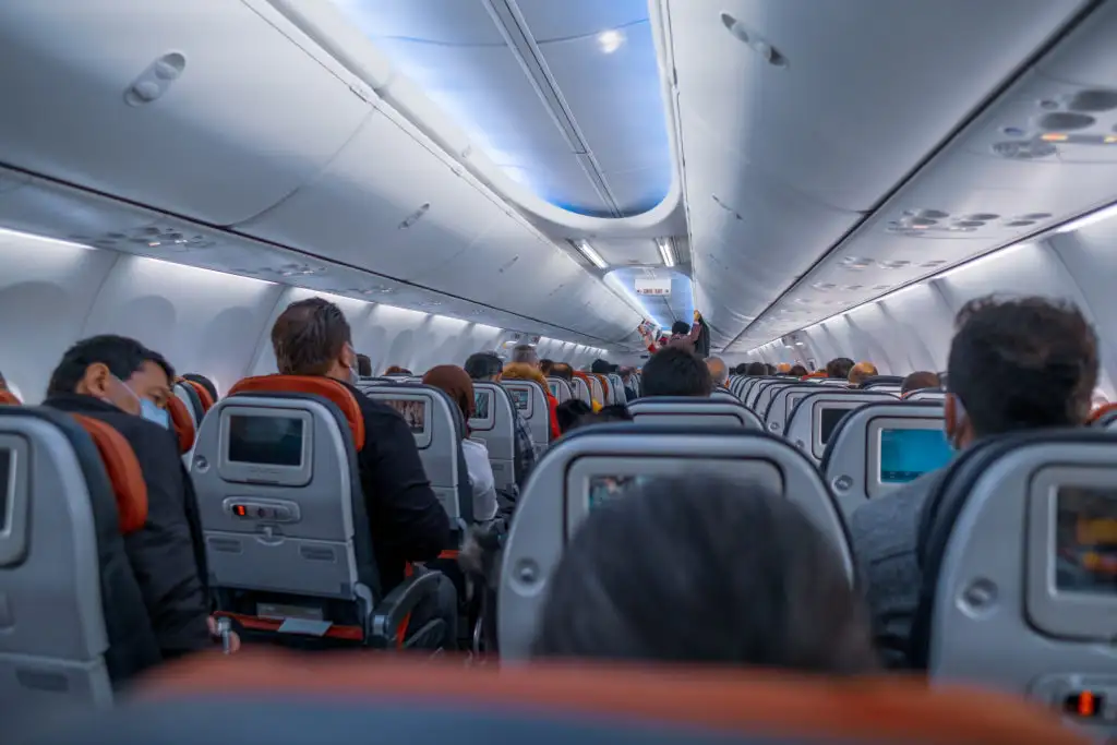 Shot of plane full of passengers as seen from back of plane