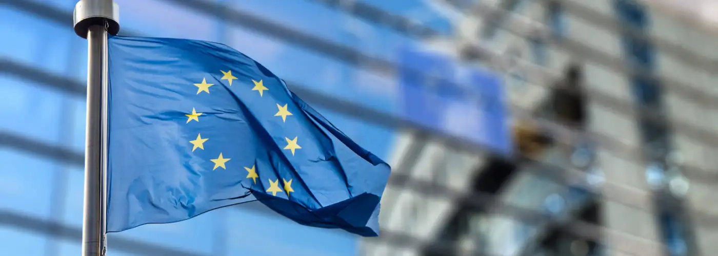 European Union flag flying in front of the European Union Parliament building