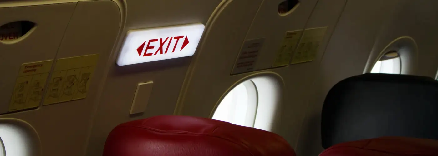 Close up of exit sign in exit row of plane