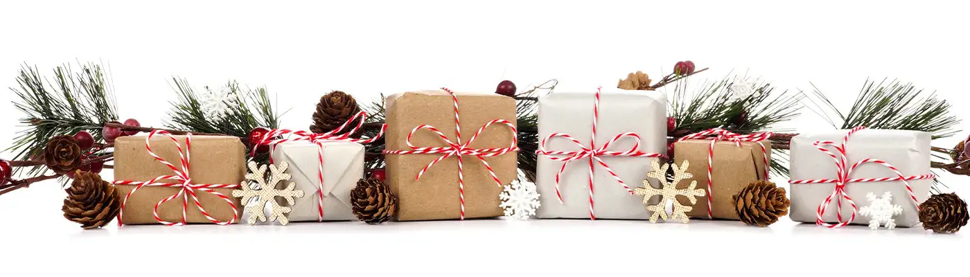 Christmas border with branches and rustic brown and white gift boxes isolated on a white background