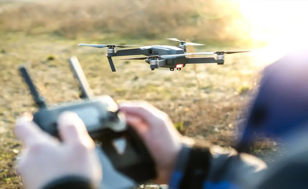 Man operating drone / man holding remote control drones / drone controller.