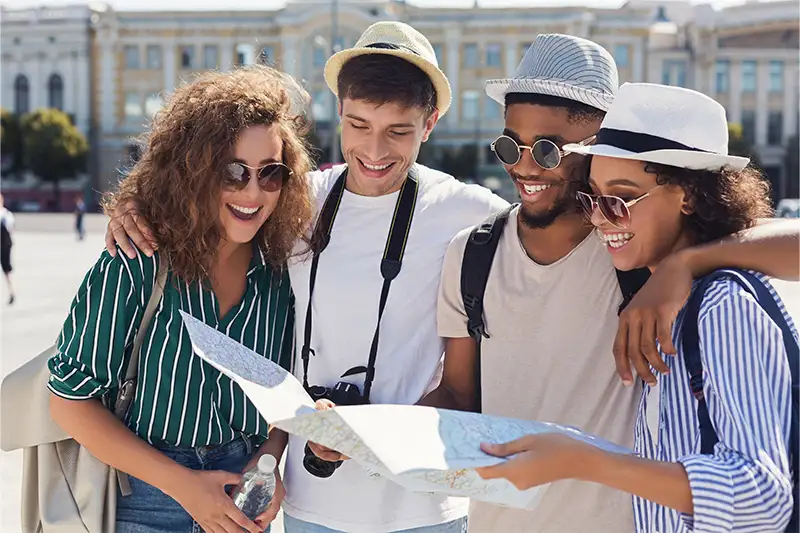 Group of friends traveling together, looking at a paper map