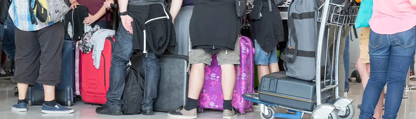 passengers in row waiting check-in counters at airport at Paris, France