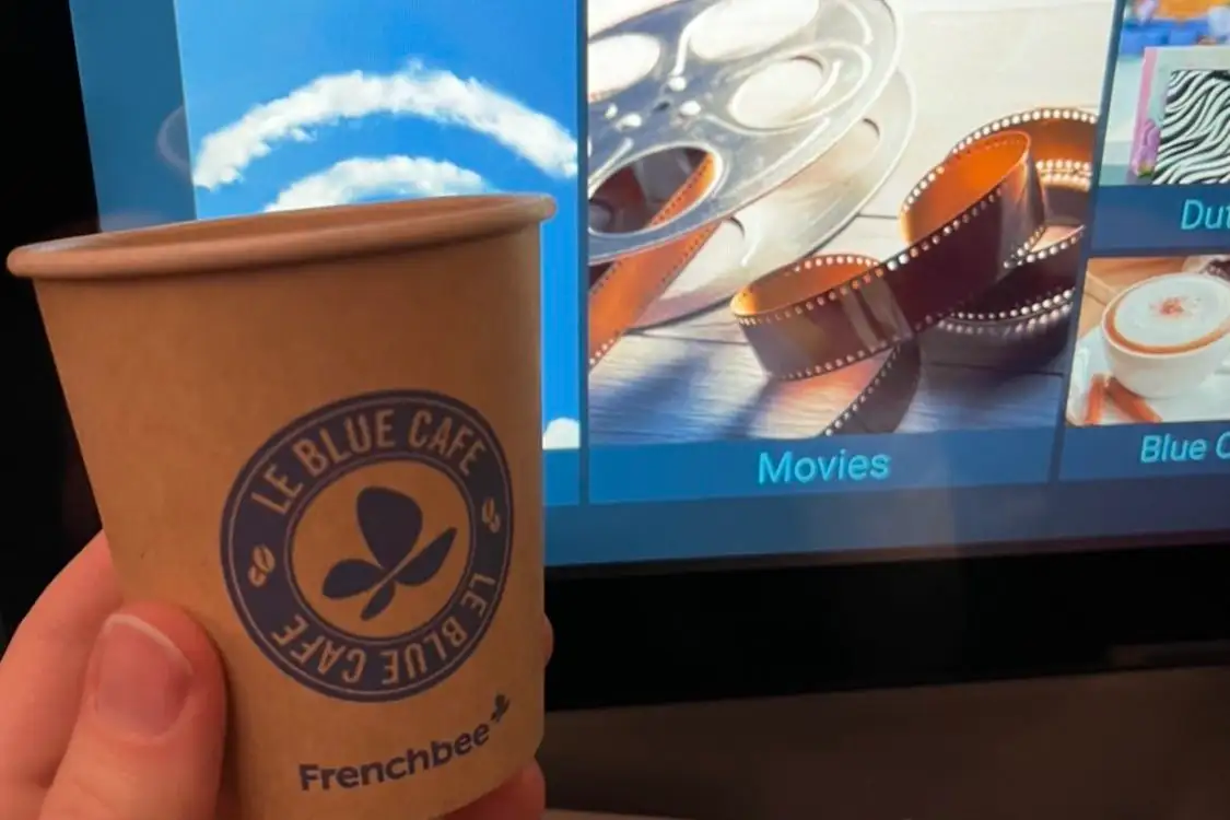 French bee "Frenchblue" cafe cup in front of a seatback LED screen