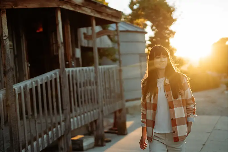 Woman walking at sunset wearing the Ember Shirtjak from Kuhl