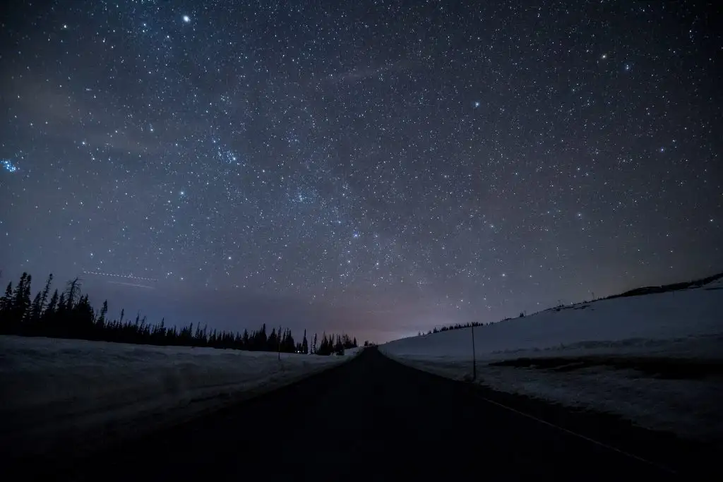 highway on dark road with bright sky stars