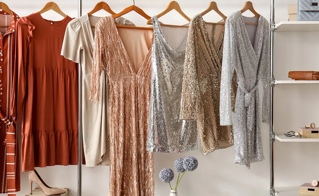 Stylish dresses hanging in wardrobe in dressing room