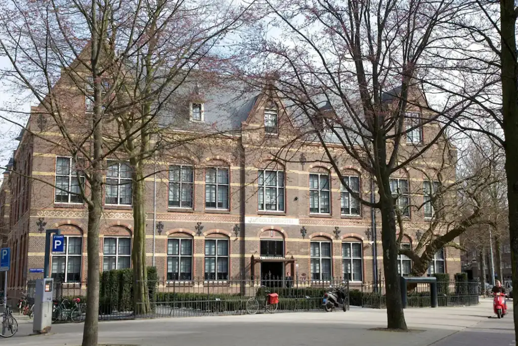 Looking through the trees at the front entrance of The College Hotel Amsterdam