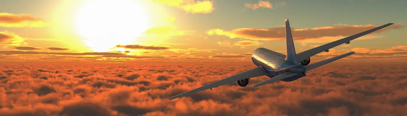 passenger plane flying into the sunset
