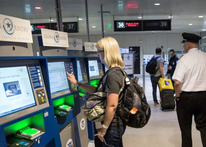 woman at global entry kiosk in Boston airport.