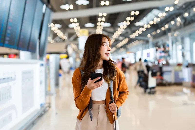 Woman using phone in the middle of an airport